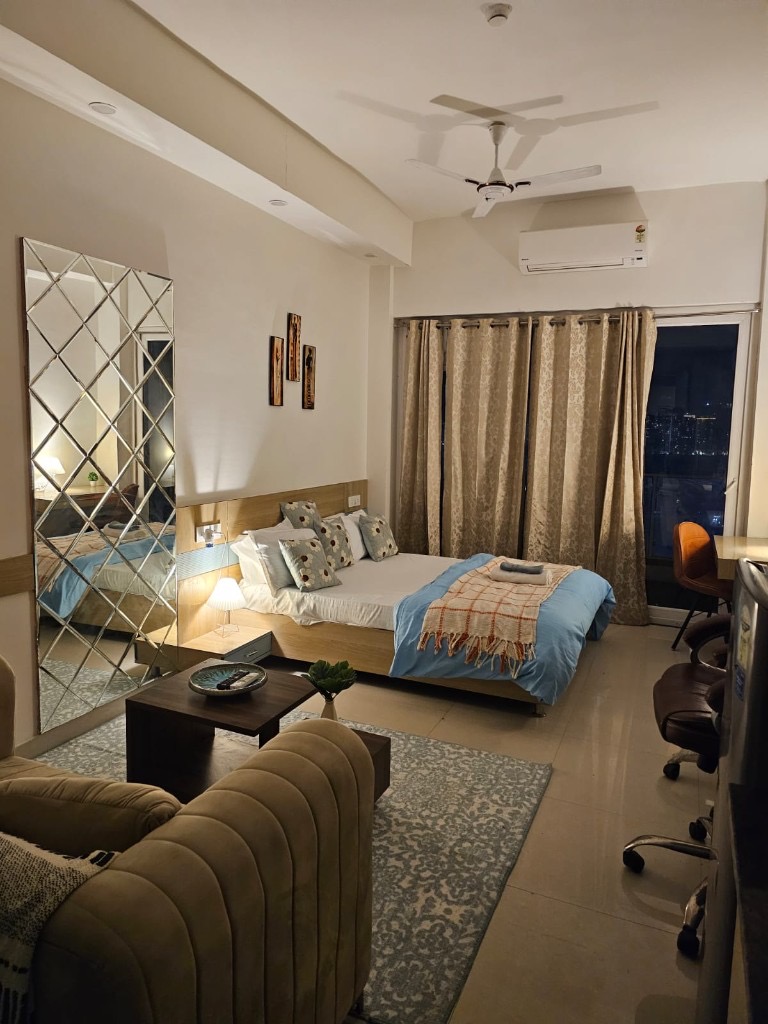 Real premium furnished VP Nest studio with bed, seating, workspace and city-view windows